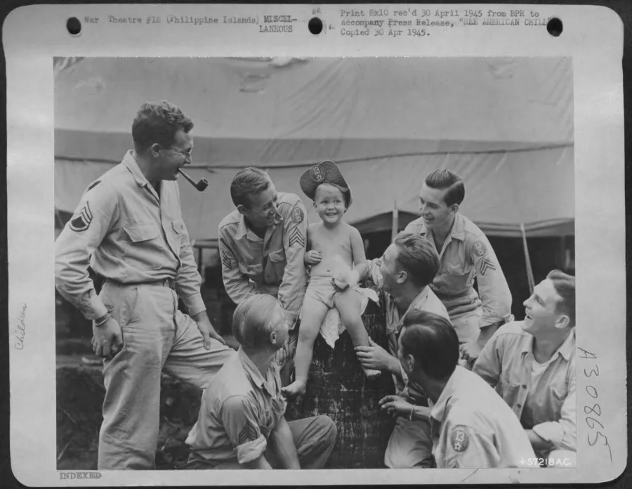 Former internee at Camp Holmes Bobby Tangen is surrounded by American soldiers after liberation in 1945.